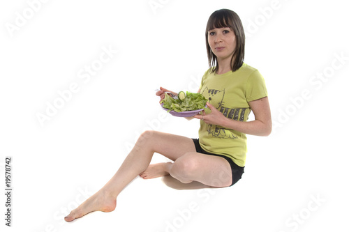 Fotografia jeune femme brune et mince qui mange de la salade