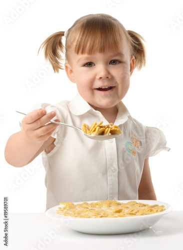 Girl showing spoon filled with corn flakes