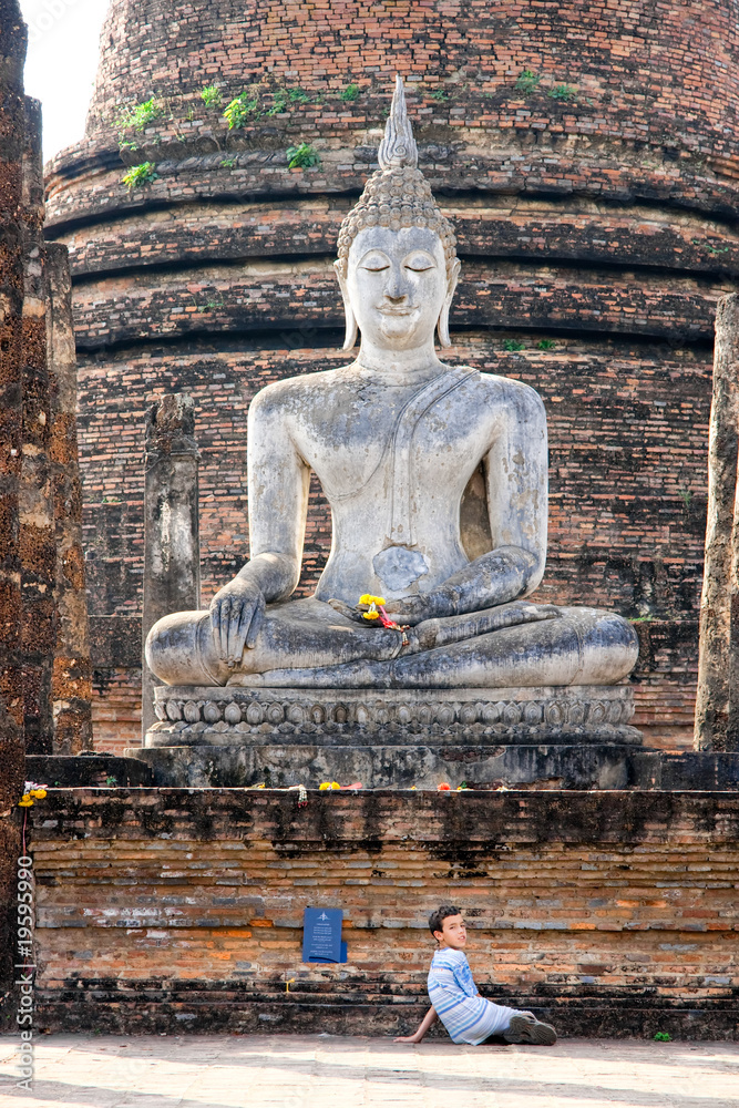 Fototapeta premium Young chilren under Buddha Statue, Sukhothai, Thailand,