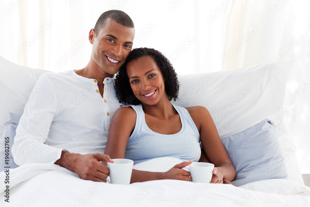 Afro-american couple drinking a coffee on their bed Afro-american couple drinking a coffee on their bed