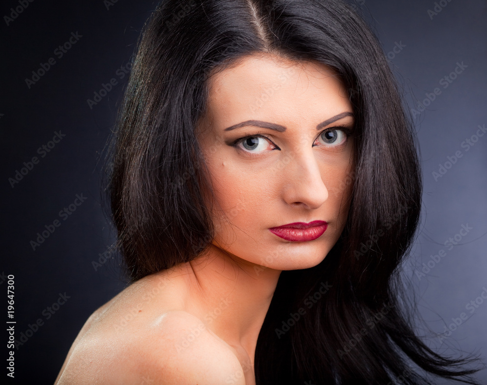 Obraz premium Beautiful young woman face over dark background