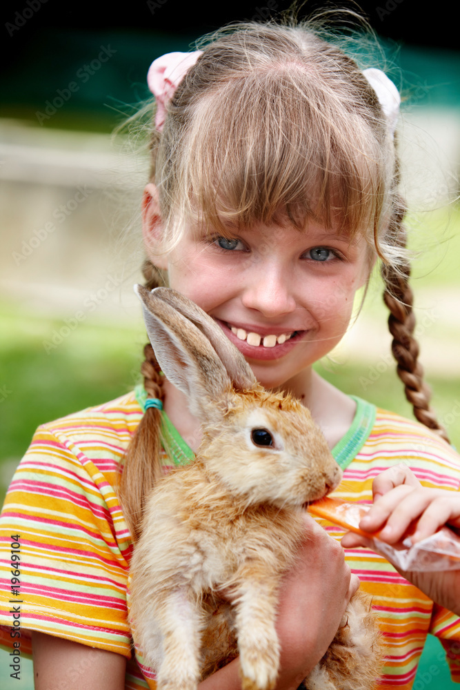 Happy girl feed rabbit with carrot. Happy girl feed rabbit with carrot.