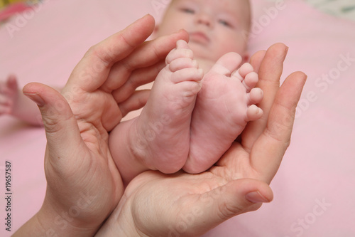 Legs baby in the hands of mothers