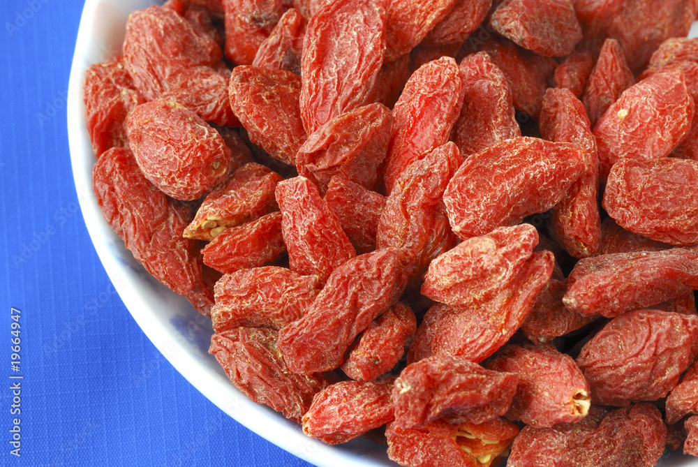 Goji berries also called wolfberries isolated on blue Goji berries also called wolfberries isolated on blue