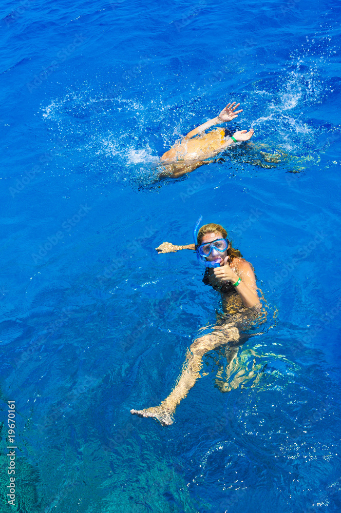 The beautiful girl is snorkeling with a mask in a red sea