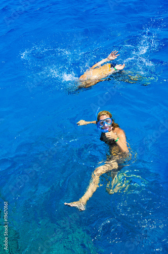 The beautiful girl is snorkeling with a mask in a red sea