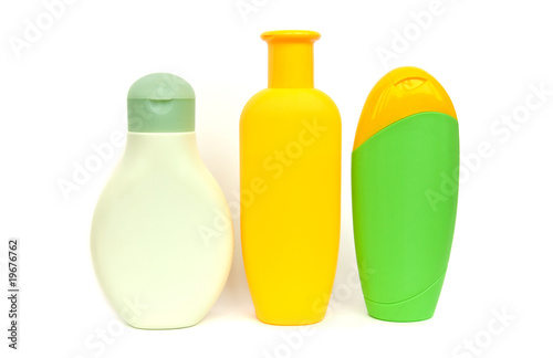 Three coloured shampoo bottles isolated on white