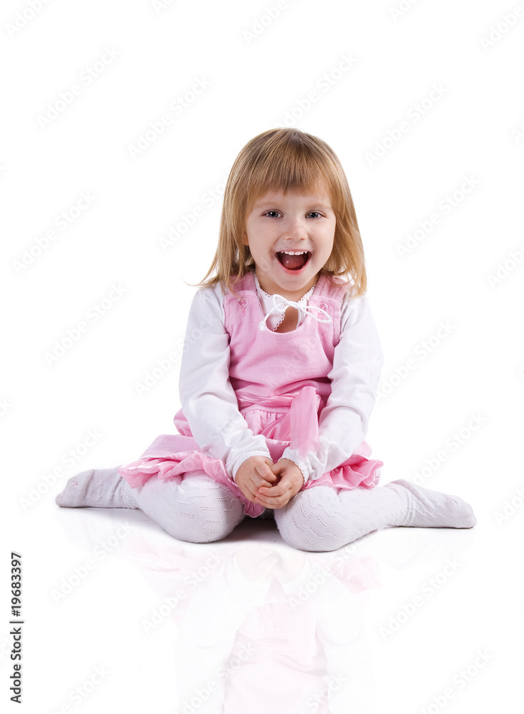 Cute little girl in a pink sit cross-legged Cute little girl in a pink sit cross-legged