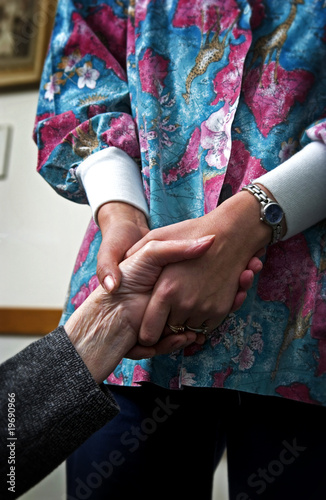 Nurse holding senior womans hand