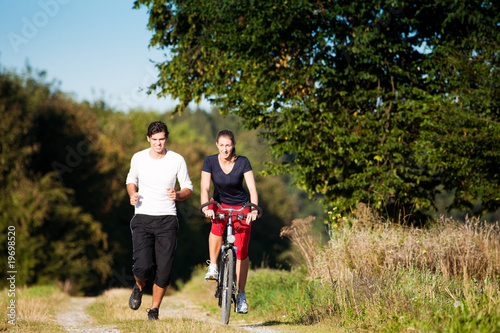 Sport-Paar joggt und fährt Farrad