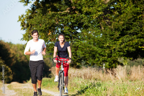 Young sport couple jogging and cycling