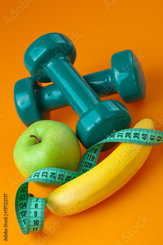 dumbells with measuring tape and fruits