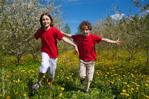 Kids running, jumping in orchard