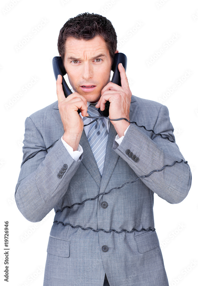Angry businessman tangle up in phone wires Angry businessman tangle up in phone wires