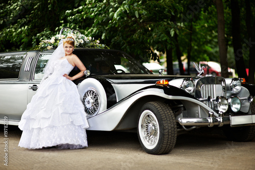 Luxury bride in a wedding dress about retro limousine © Sergey Ryzhov