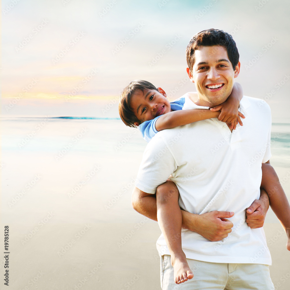 Father giving son piggyback ride at the beach Father giving son piggyback ride at the beach