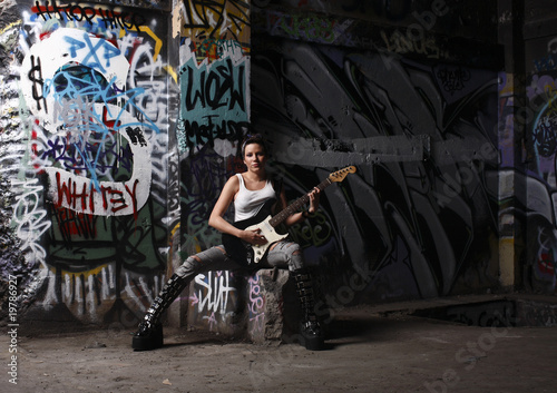 young and sexy female rock musician with her guitar