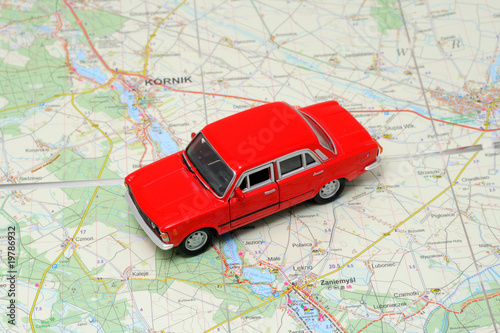 Tiny red car model on the road map