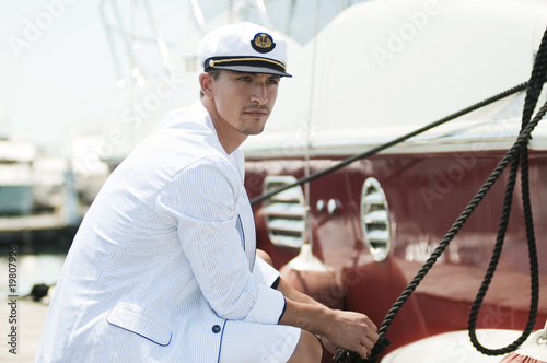 captain holding rope of the yacht