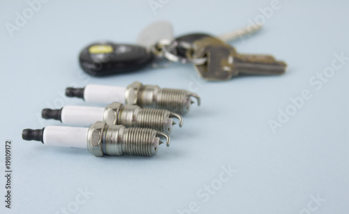 three sparkplugs keys in background
