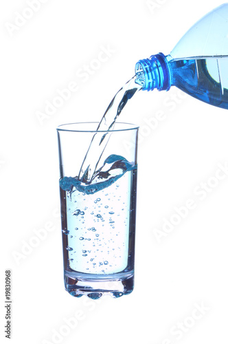 Water falling in glass from bottle