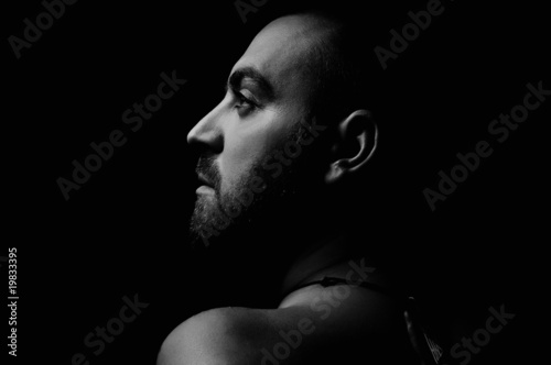 young nude adult man face portrait in dark