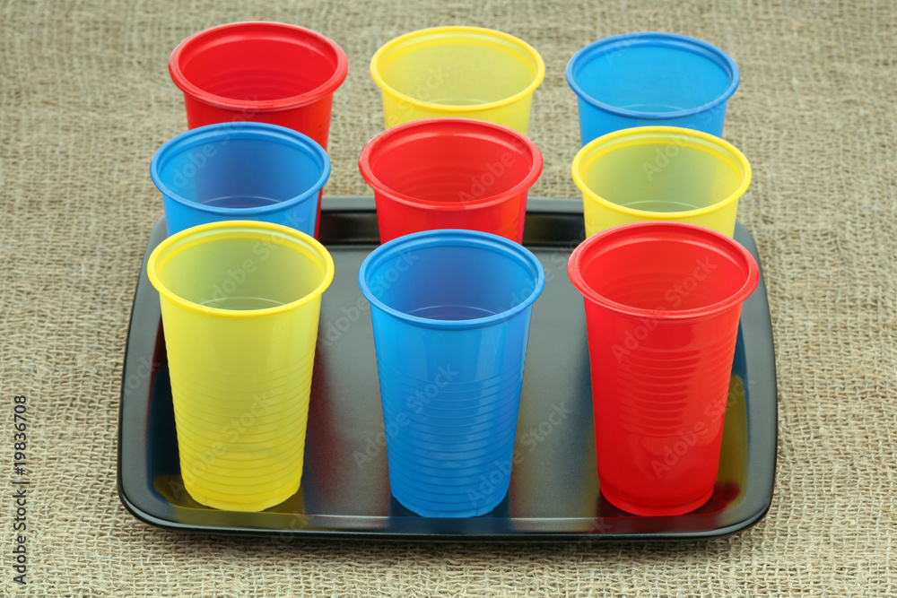 Multi-coloured plastic glasses on a ceramic tray Multi-coloured plastic glasses on a ceramic tray