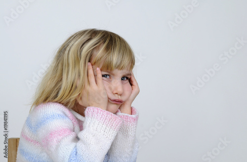 Canvastavla Kleines Maedchen stuetzt bockig den Kopf in die Haende.