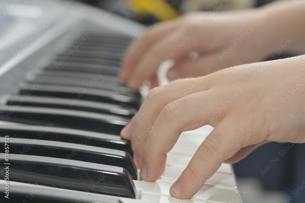 Fototapeta premium boys hands playing piano keyboard
