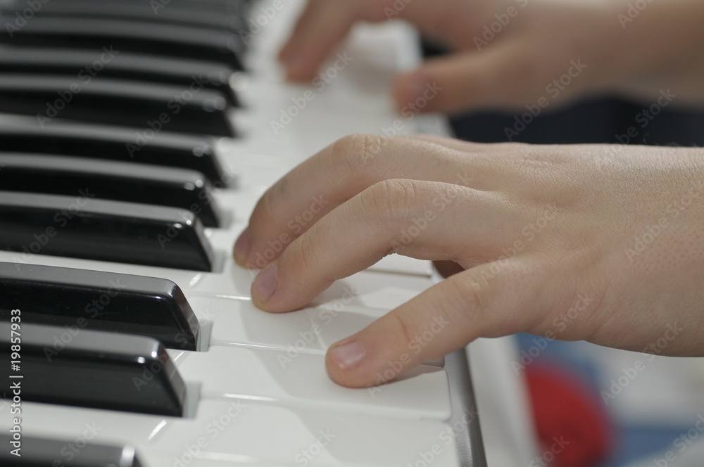 Obraz premium boys hands playing piano keyboard