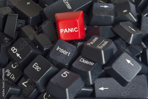 Stack of black computer keyboard keys with red panic button