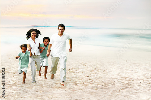 Excited family happily running down the beach