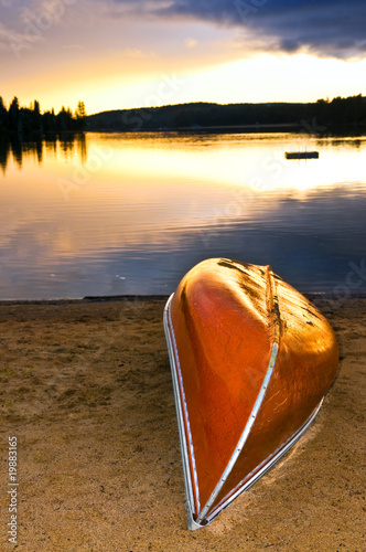 Lake sunset with canoe on beach