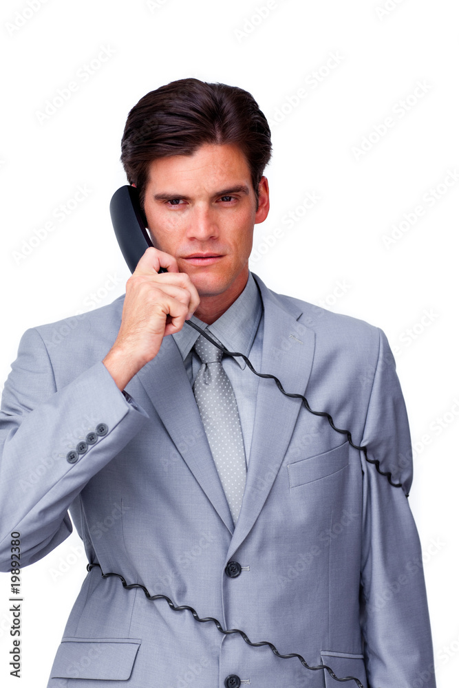 Annoyed businessman tangle up in phone wires Annoyed businessman tangle up in phone wires