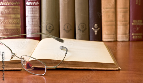 Eyeglasses on open vintage book photo