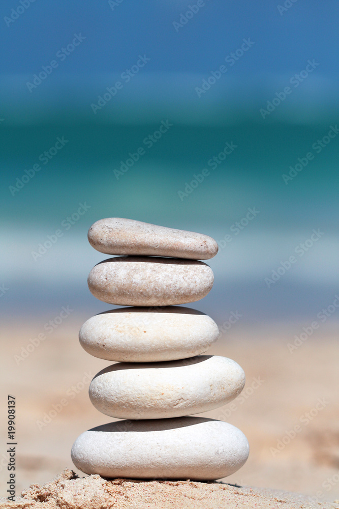 Stack of white stones on the sand with sea in backgorund Stack of white stones on the sand with sea in backgorund