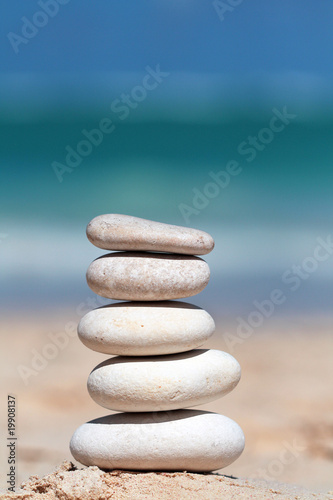Stack of white stones on the sand with sea in backgorund