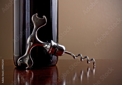 Wine bottle and a corkscrew in a dark cellar