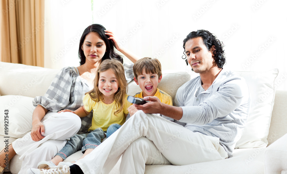 Excited little boy watching TV with his family Excited little boy watching TV with his family