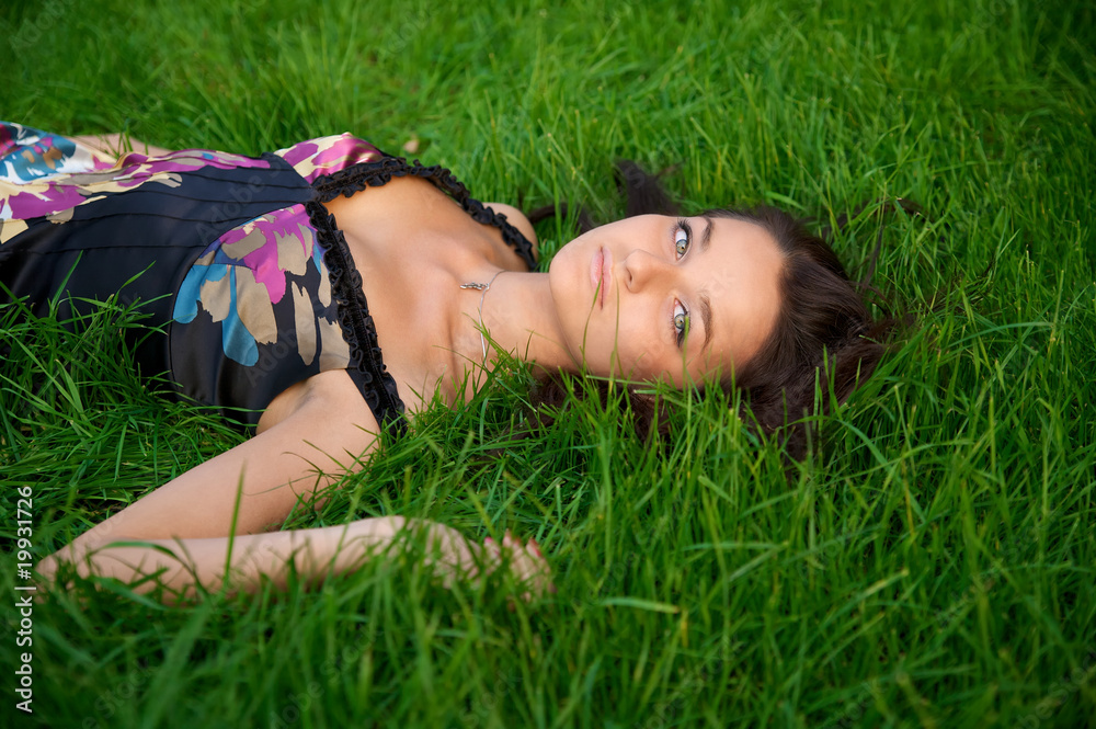 Young beautiful woman lying on a green grass Young beautiful woman lying on a green grass