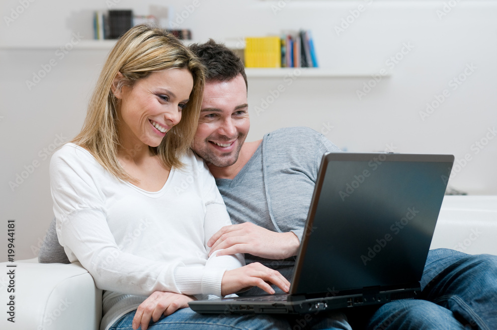 Smiling young couple with laptop