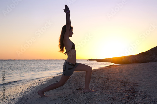 girl  practicing yoga against sunset