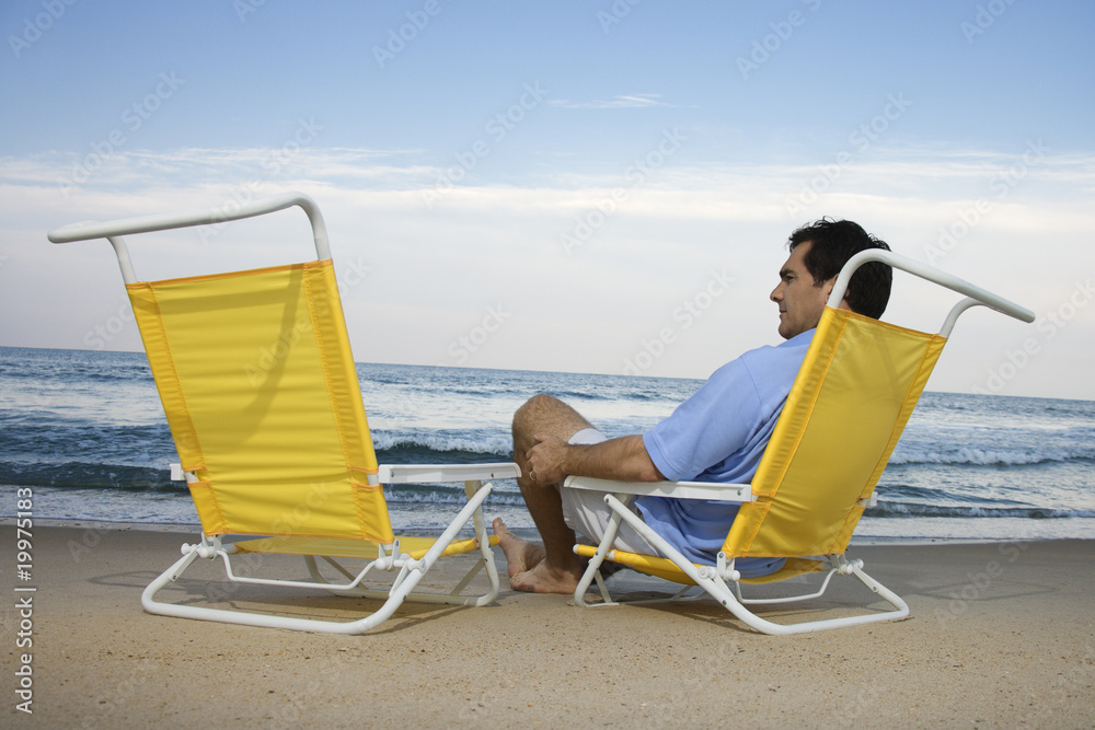 Man Sitting on Beach Alone
