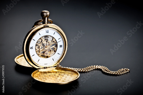 Old vintage pocket clock against the black background