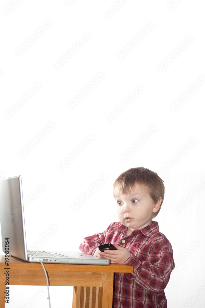 boy using cell phone and laptop boy using cell phone and laptop