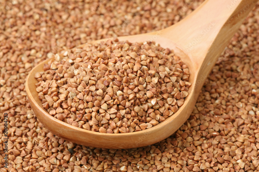 Small buckwheat groats in a wooden spoon Small buckwheat groats in a wooden spoon