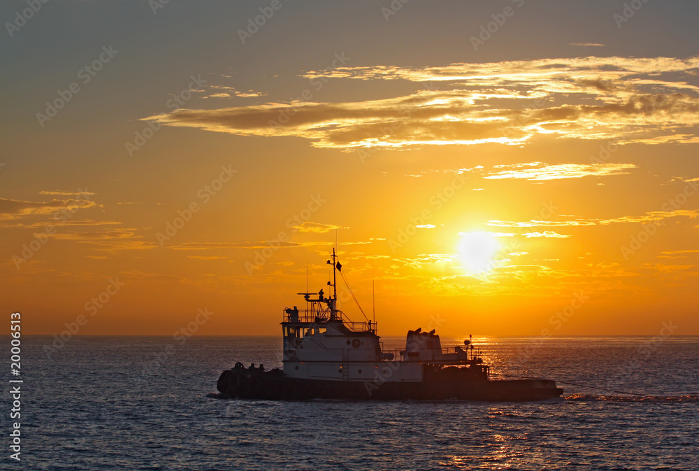 Silhouette of a tug boat at sunset