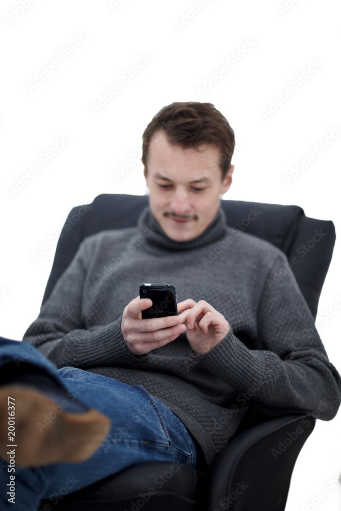 Guy in a chair writing sms to his friends
