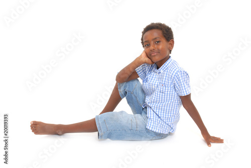 niño sonriente sentado en el suelo aislado