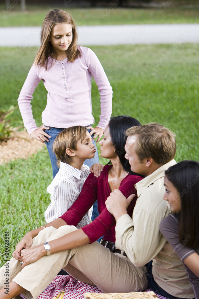 Affectionate interracial family of five enjoying picnic together Affectionate interracial family of five enjoying picnic together
